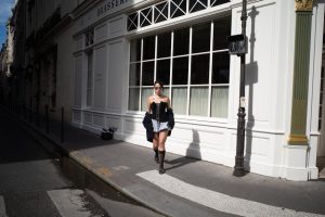 Mujer con estilo parisino vistiendo prendas vintage francesas en una calle empedrada