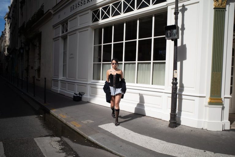 Mujer con estilo parisino vistiendo prendas vintage francesas en una calle empedrada