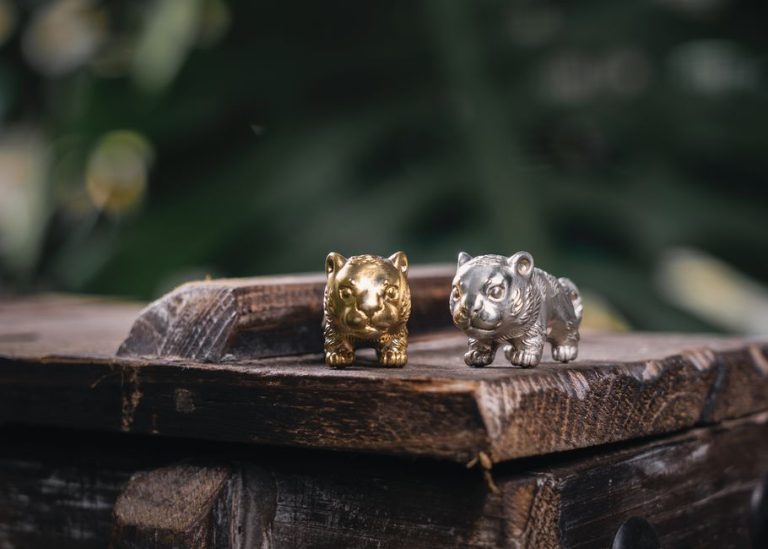 Figuras de animales en miniatura de bronce y cerámica sobre estante de madera