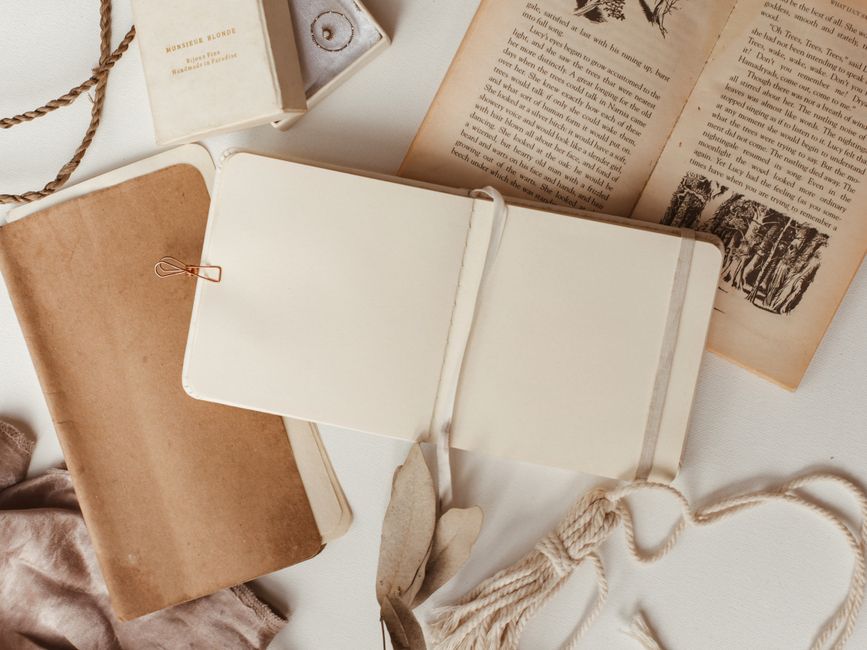 Cuaderno pequeño de journaling artesanal abierto sobre escritorio con pluma y café