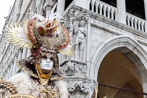 Máscara veneciana artesanal con plumas exóticas y pan de oro, detalle de acabado lujoso