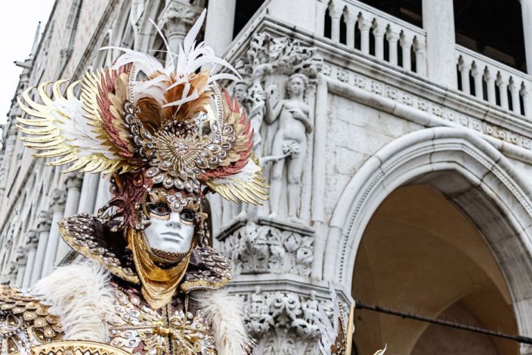 Máscara veneciana artesanal con plumas exóticas y pan de oro, detalle de acabado lujoso