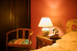 Lámpara de mesita de noche vintage con base de cerámica y luz cálida en dormitorio
