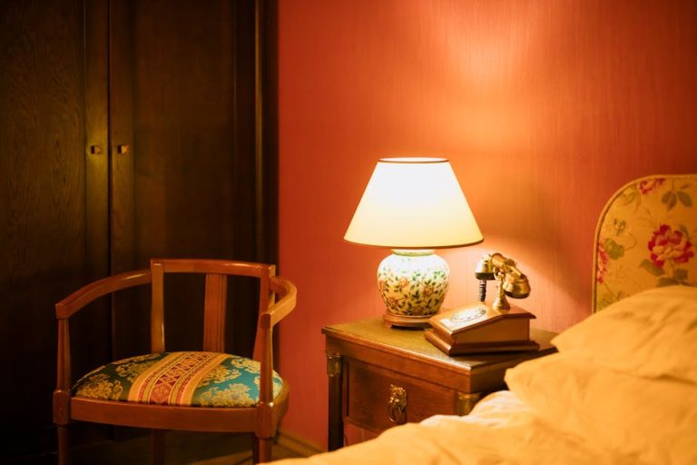 Lámpara de mesita de noche vintage con base de cerámica y luz cálida en dormitorio