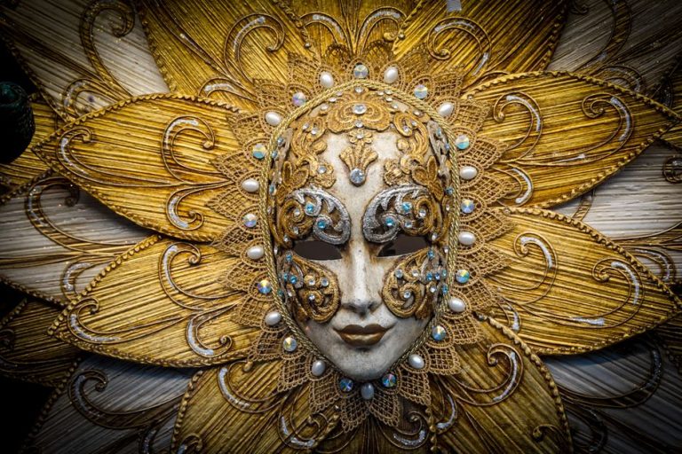 Máscara veneciana artesanal dorada con decoración barroca, símbolo del Carnaval de Venecia