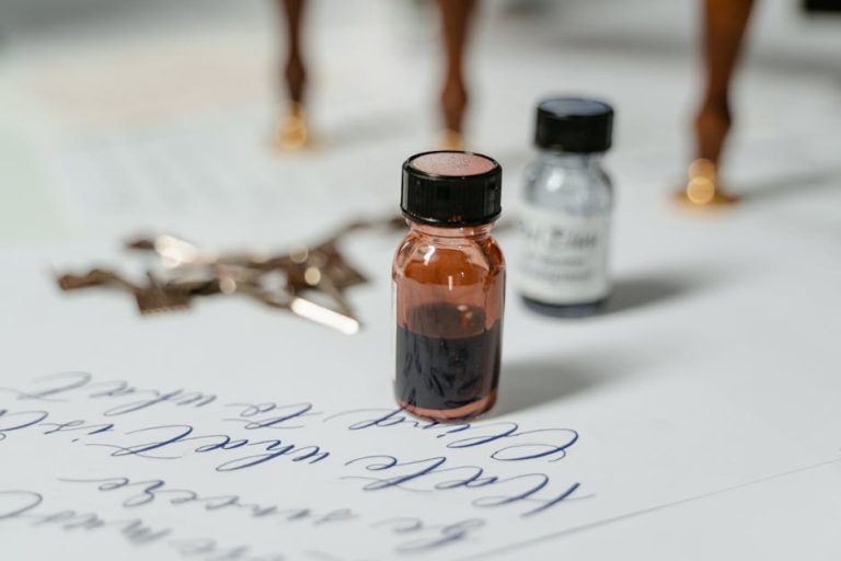 Frasco de tinta antigua junto a pluma estilográfica sobre papel pergamino