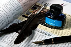 Alumno practicando caligrafía con pluma de ave y tinta en un curso de Tenerife