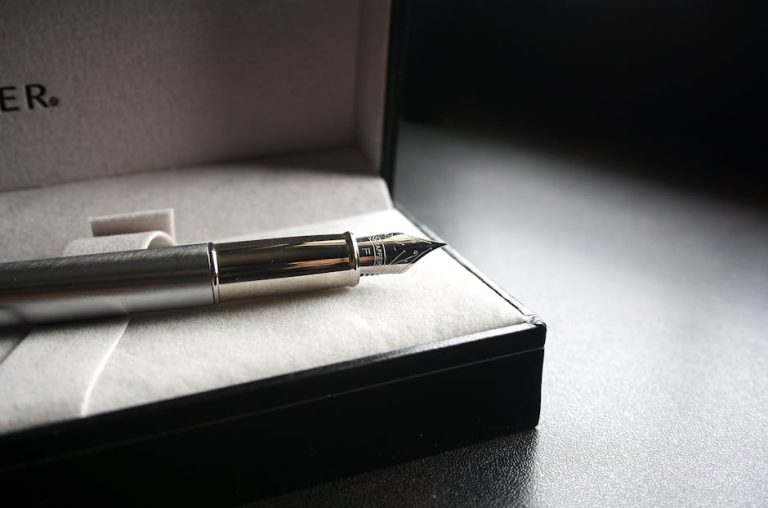 Caja de regalo con pluma estilográfica y frasco de tinta sobre madera