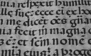 Caligrafía gótica medieval escrita con pluma de ave sobre papel envejecido