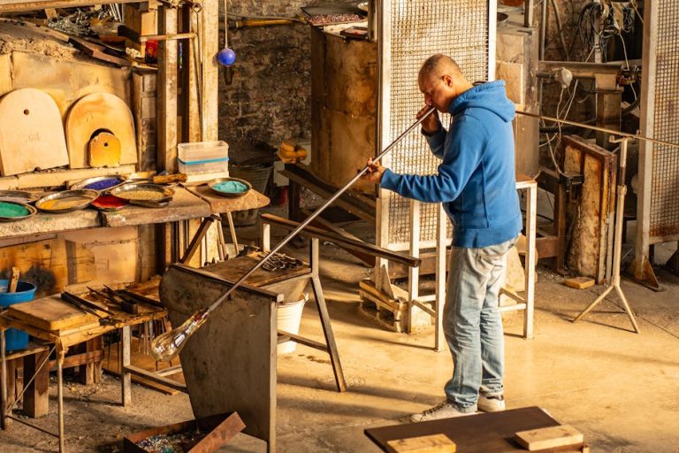 Artesano veneciano pintando a mano una máscara de papier-mâché auténtica en su taller
