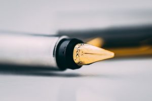 Primer plano de plumín de pluma estilográfica dorado sobre papel