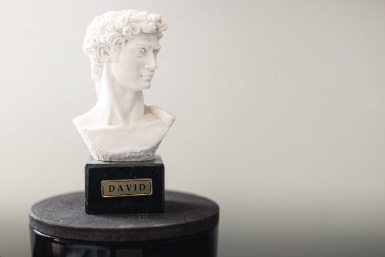 Réplica de escultura clásica grecorromana en mármol blanco sobre pedestal