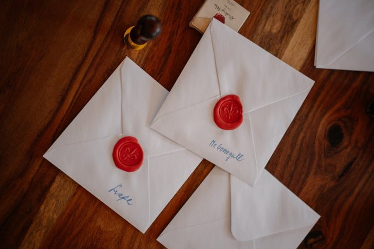 Invitación de bautizo con sello de lacre blanco perla y cinta dorada