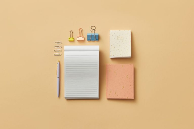 Colección de cuadernos en miniatura artesanales dispuestos en abanico sobre mesa de madera
