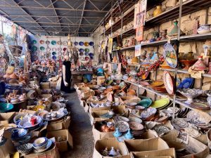 Puesto de artesanía en un zoco marroquí con vasijas de cerámica y objetos decorativos étnicos