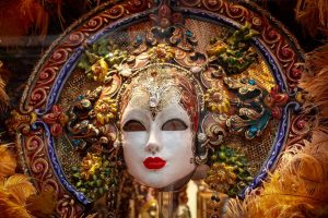 Máscaras venecianas decorativas colgadas en pared de salón con iluminación artística