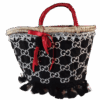 Bolso capazo de tejido con monograma negro y blanco, lazo rojo y flecos Bolso capazo de tejido con monograma negro y blanco, lazo rojo y flecos