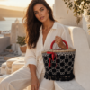 Bolso capazo de tejido con monograma negro y blanco, lazo rojo y flecos Bolso capazo de tejido con monograma negro y blanco, lazo rojo y flecos